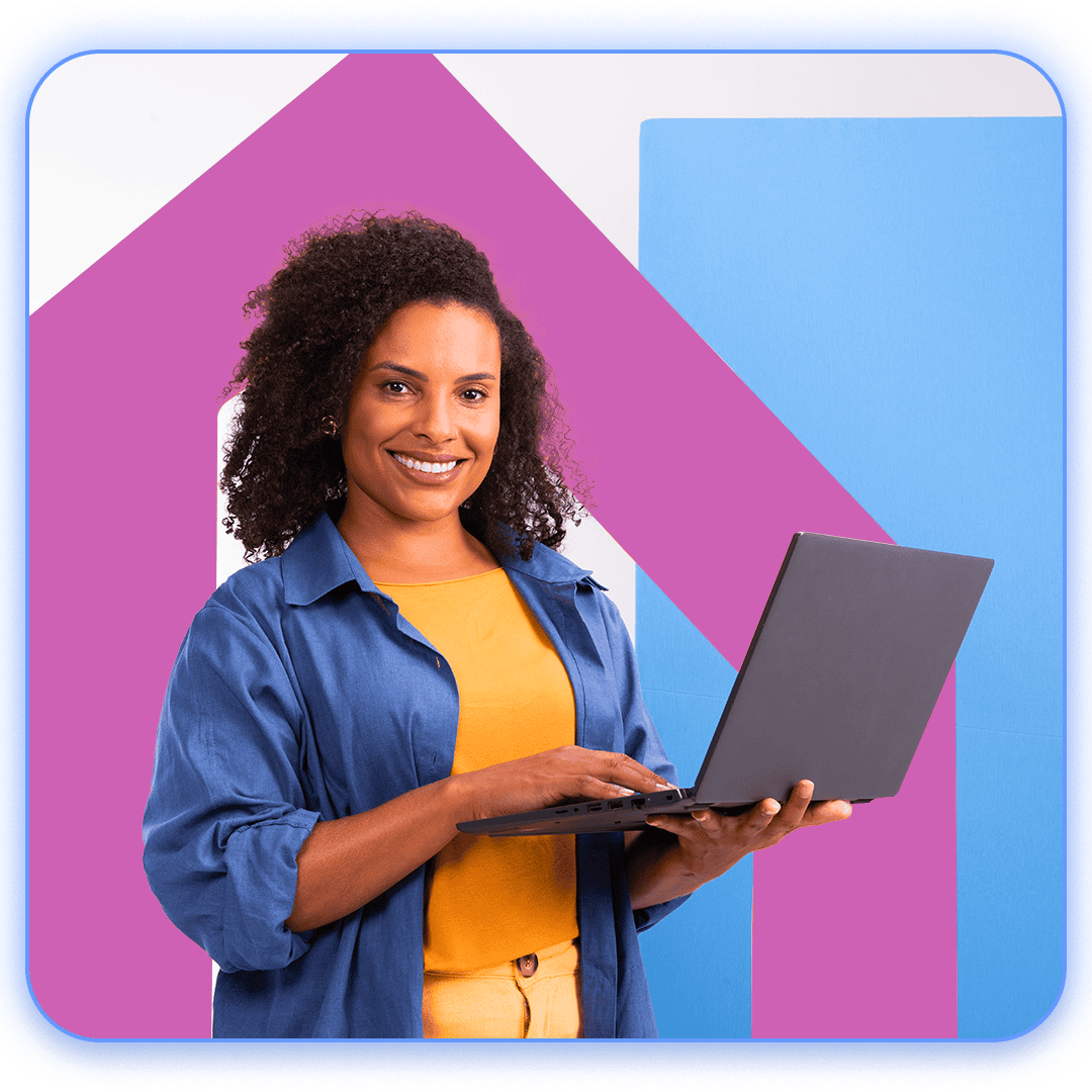 Mulher sorridente com um notebook na mão, em seu ambiente de trabalho